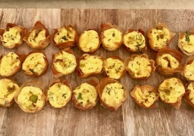 Mini quiches on a wooden board.