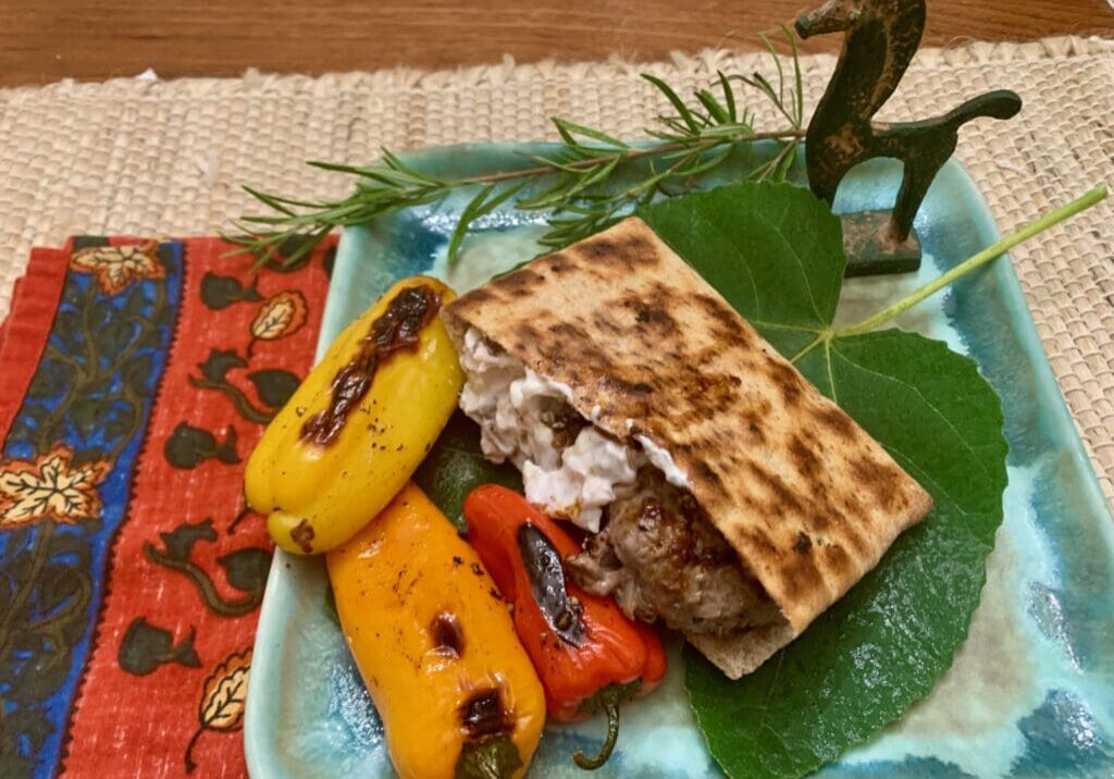 Grilled pita, peppers, and meat on plate.