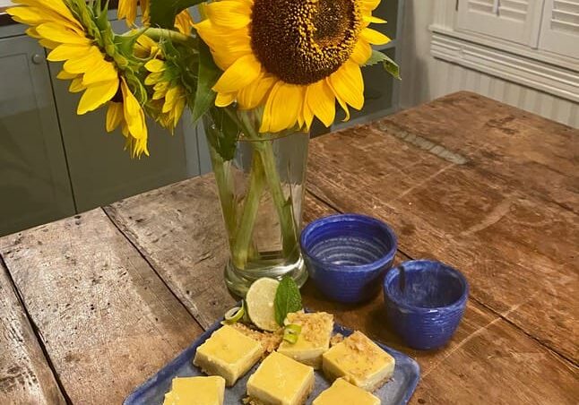 A table with some food and a vase of flowers