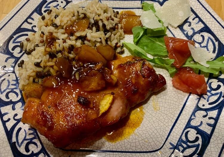 A plate of food with rice and meat on it.