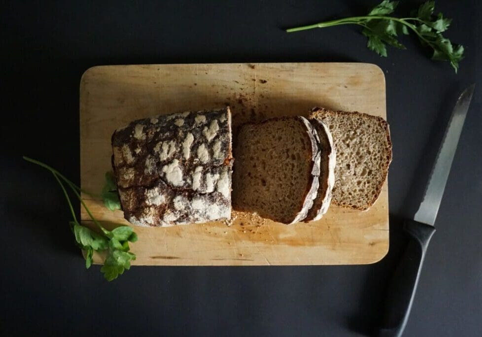 A loaf of bread with a cut in half.