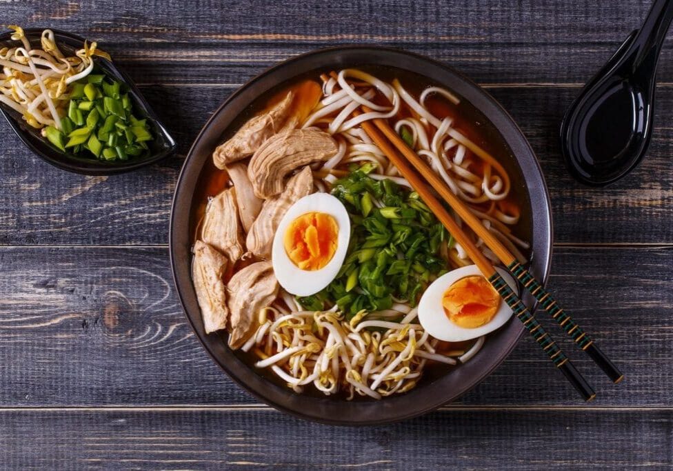 A bowl of ramen with chicken and eggs.