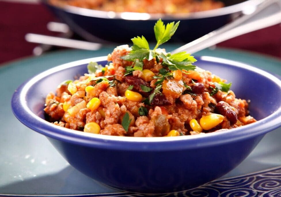 A bowl of rice and beans with cilantro.