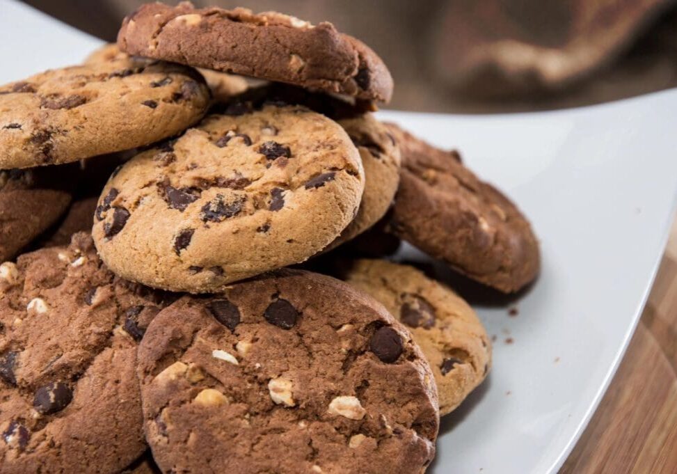 A pile of cookies sitting on top of a white plate.