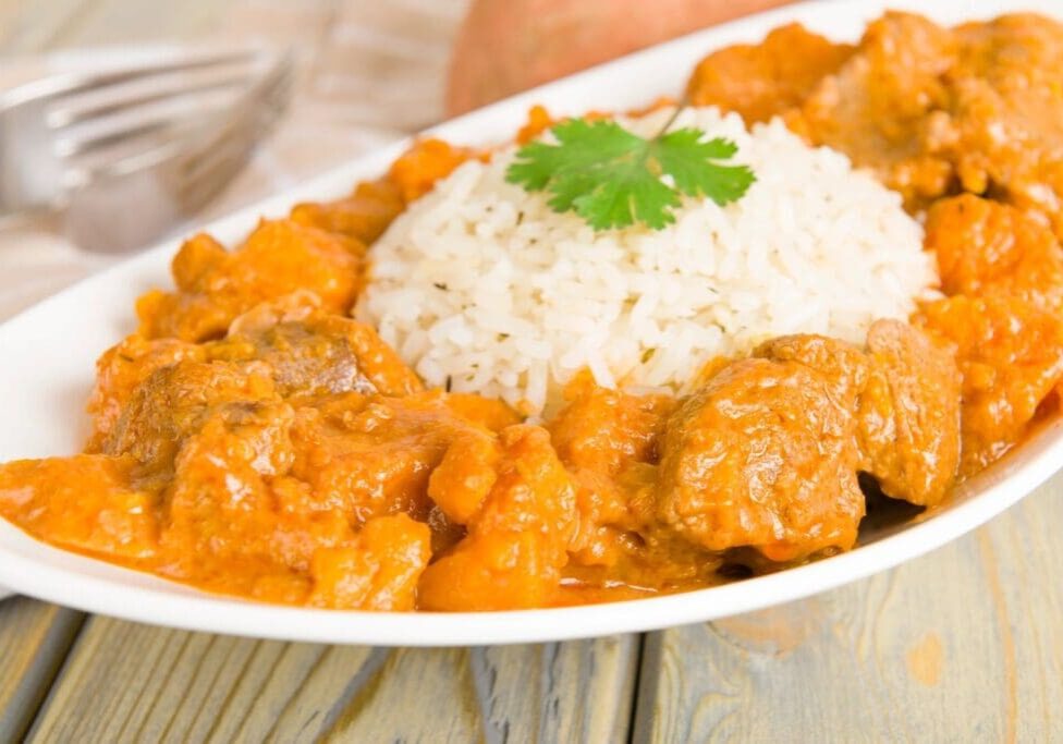 A plate of food with rice and meat on it.