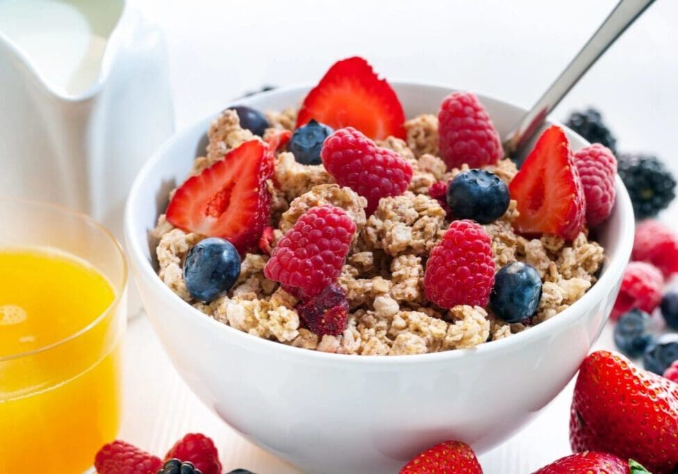 A bowl of cereal with berries and bananas