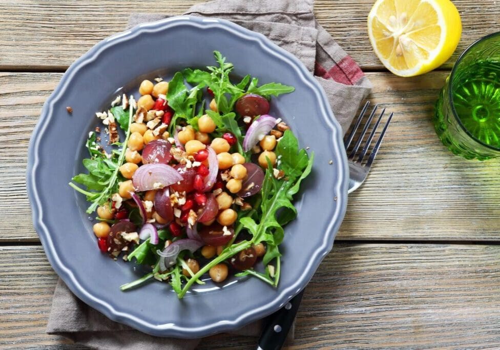 A bowl of salad with chickpeas and greens.