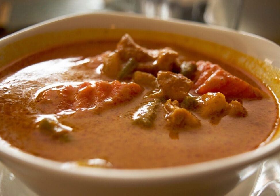 A bowl of soup with meat and vegetables.