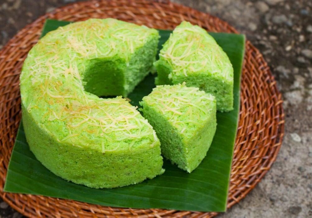 A green cake is on the plate and ready to be eaten.