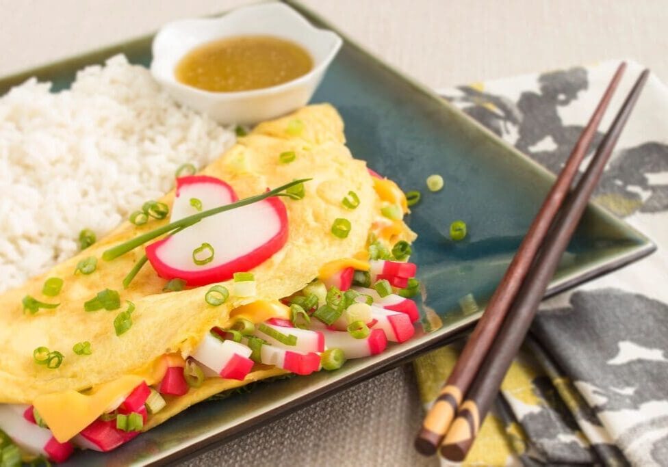 A plate of food with rice and sauce on the side.