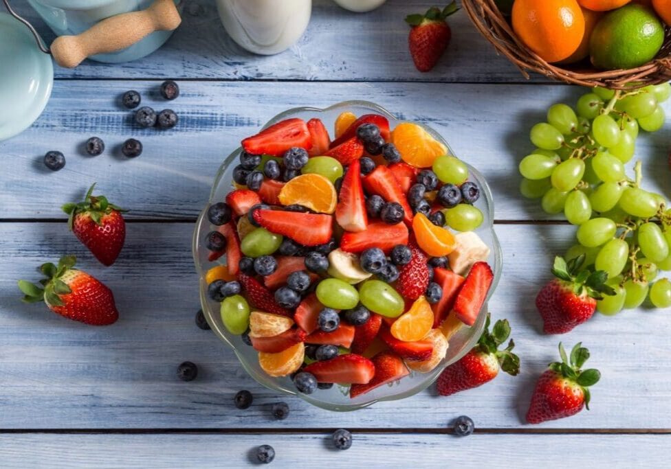 A bowl of fruit is sitting on the table.