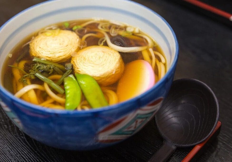 A bowl of soup with noodles and vegetables.