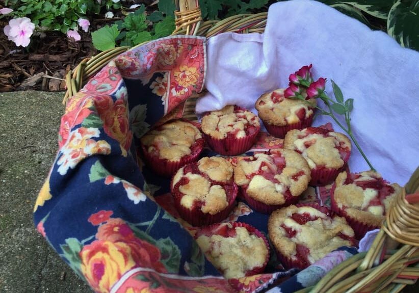 A basket of muffins sitting on top of the ground.