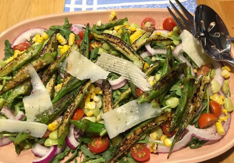 A plate of salad with asparagus, corn and tomatoes.