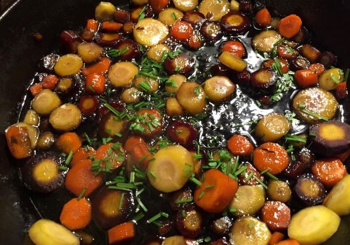 A pan filled with carrots and other vegetables.