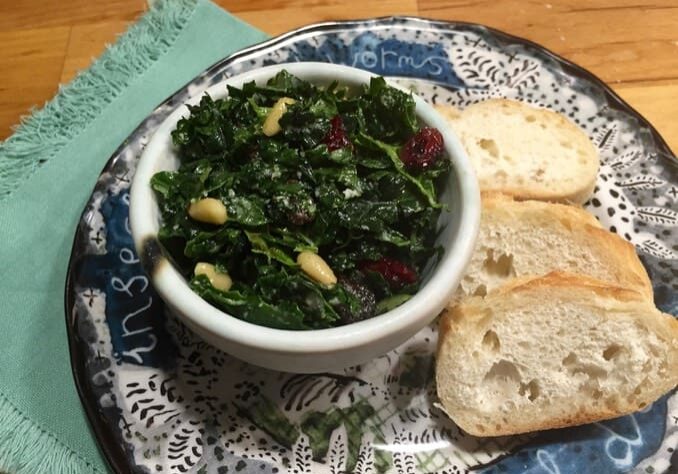 A bowl of greens and bread on a plate.