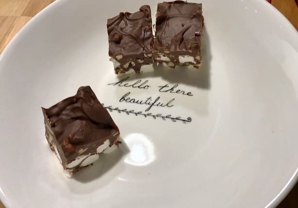 A plate with some chocolate covered marshmallows on it