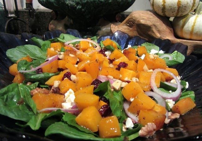 A salad with spinach, feta cheese and orange.