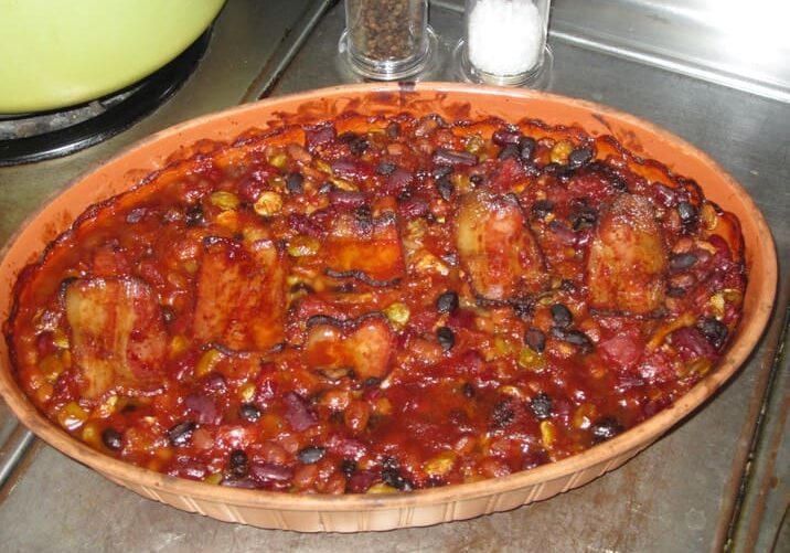 A bowl of chili with beans on top.