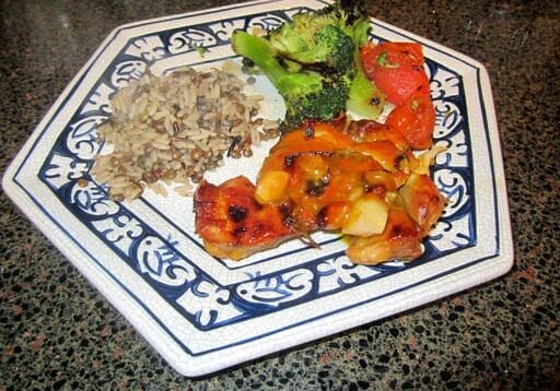 A plate of food with rice, broccoli and tomatoes.