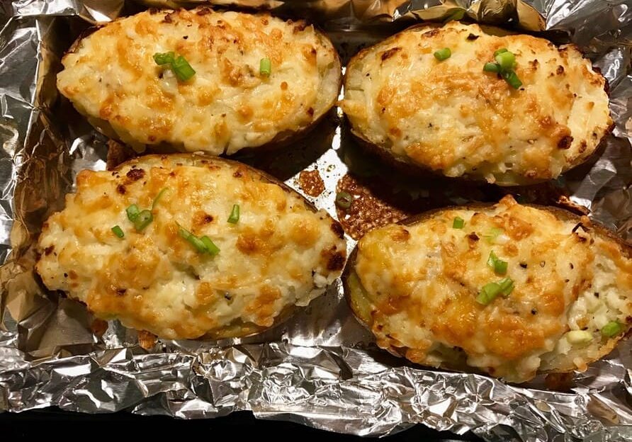 A close up of some baked potatoes on foil