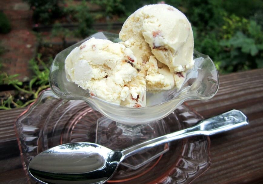 A bowl of ice cream sitting on top of a wooden table.