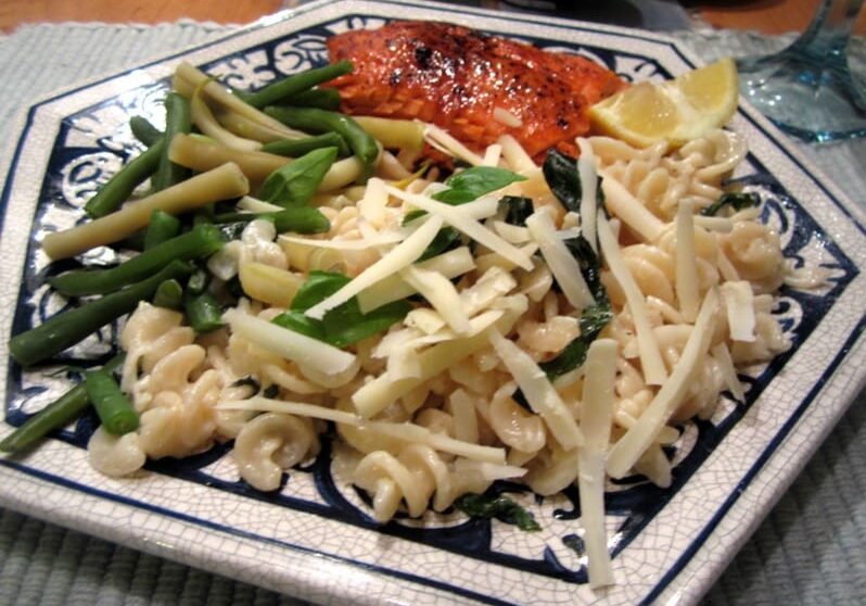 A plate of pasta with asparagus and lemon.