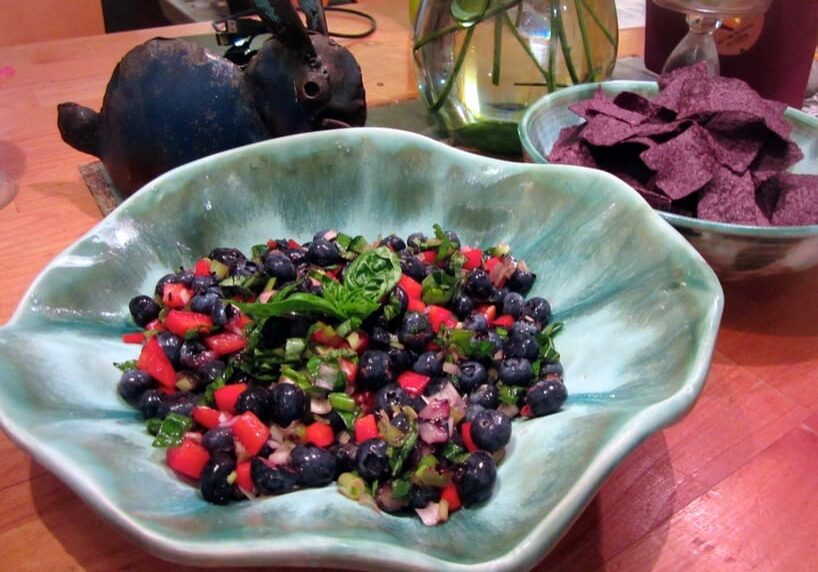 A bowl of fruit and vegetables on the table.