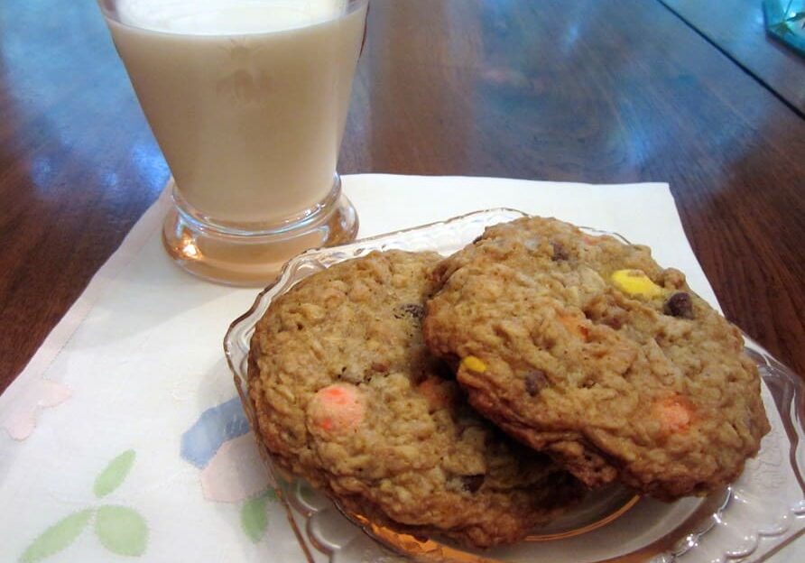 A glass of milk and cookies on the table.