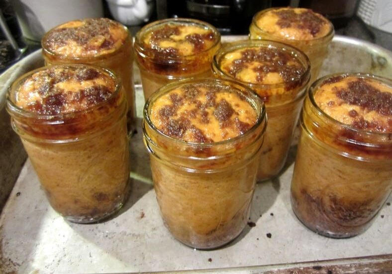 A tray of jars filled with pudding and chocolate.