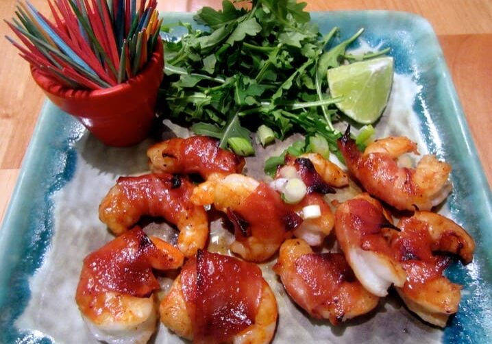 A plate of food with shrimp and greens.