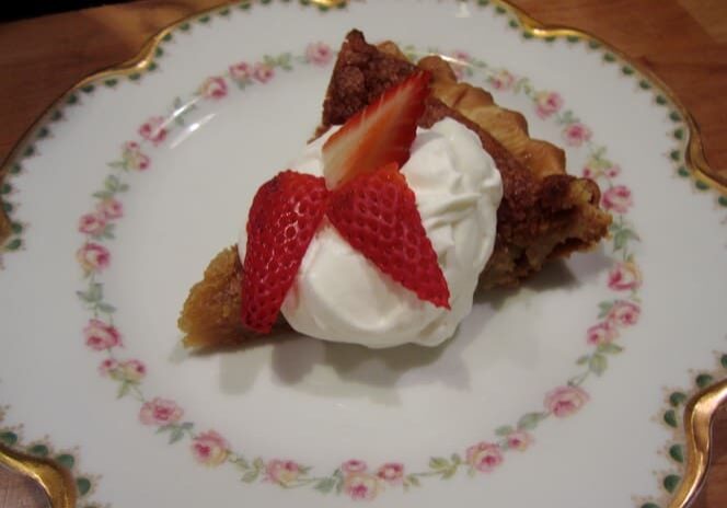 A piece of pie with strawberries and whipped cream on top.