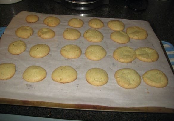 A tray of cookies on top of a stove.