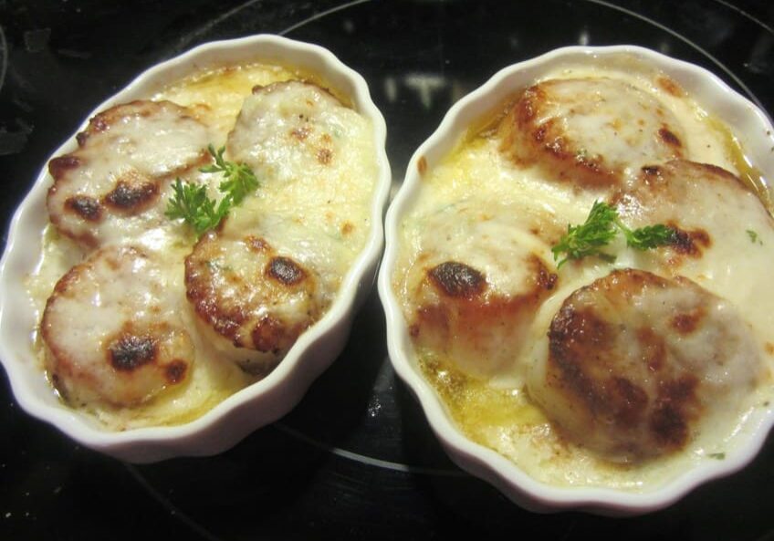 Two dishes of food on a stove top.