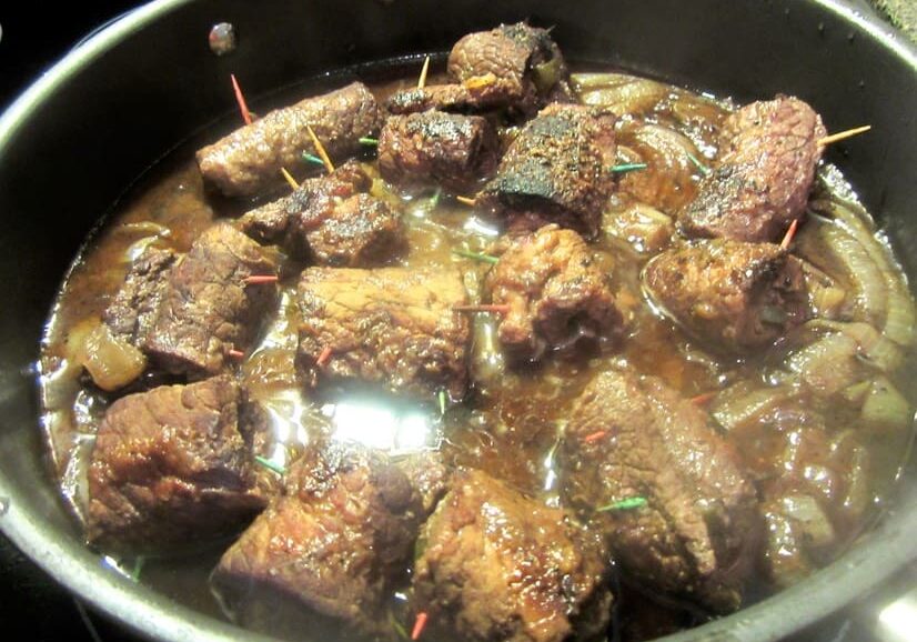 A pan of stew with meat in it.