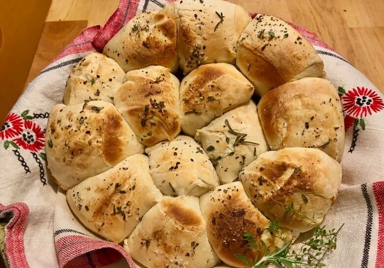 A plate of bread with herbs on it.