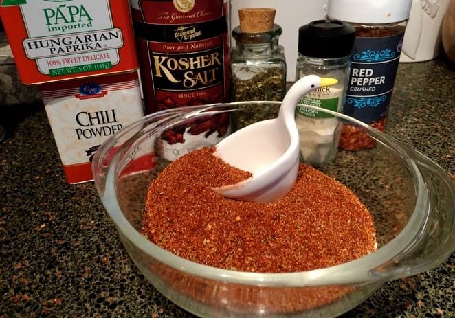 A bowl of chili powder and a spoon in it.