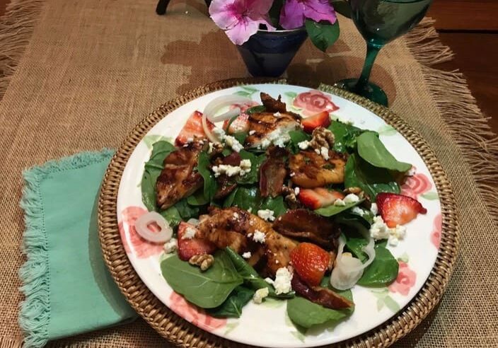 A plate of food on the table with flowers.