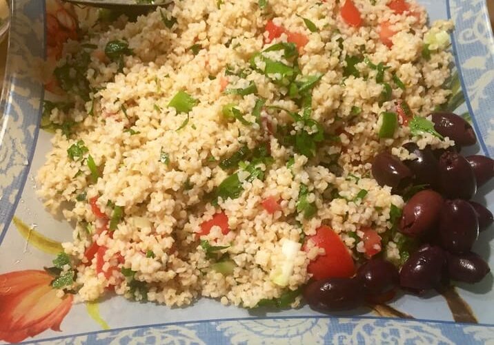 A plate of rice and grapes on the table.