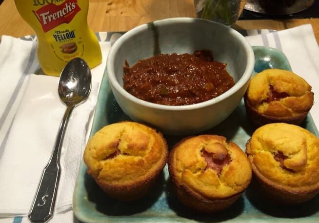 A plate of muffins and chili on the table.