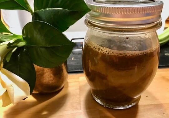 A mason jar filled with liquid sitting on top of a table.