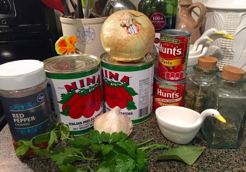 A table with many cans of tomatoes and garlic.