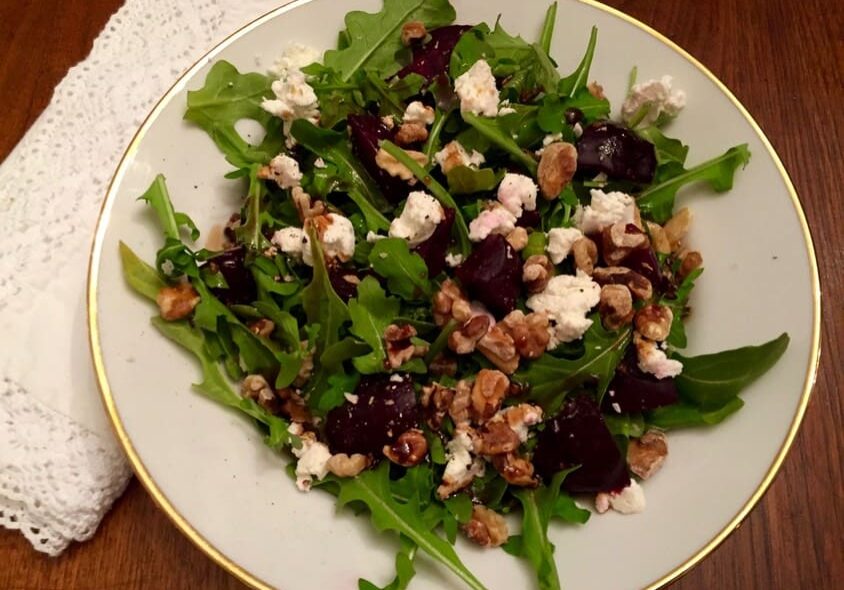 A salad with feta cheese and beets on top of it.