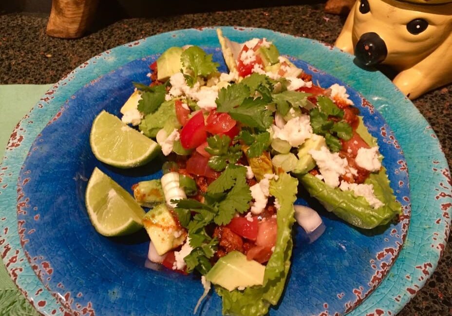 A blue plate topped with avocado and lime.